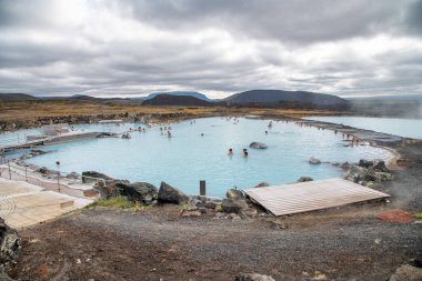 MYVATN, ICELAND - 6 AĞUSTOS 2019: Bulutlu bir yaz gününde turistlerle Myvatn Doğa Hamamları.