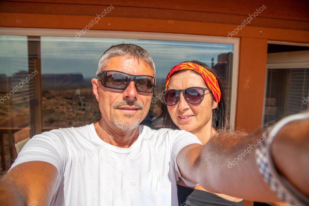 Couple having fun taking selfies on a terrace in front of Monument Valley, USA.