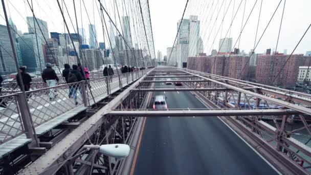 НЬЮ-ЙОРК Сити, США - 5 ДЕКАБРЯ 2018 года: Автомобильное движение и туристы на закате над Бруклинским мостом, замедленная съемка — стоковое видео