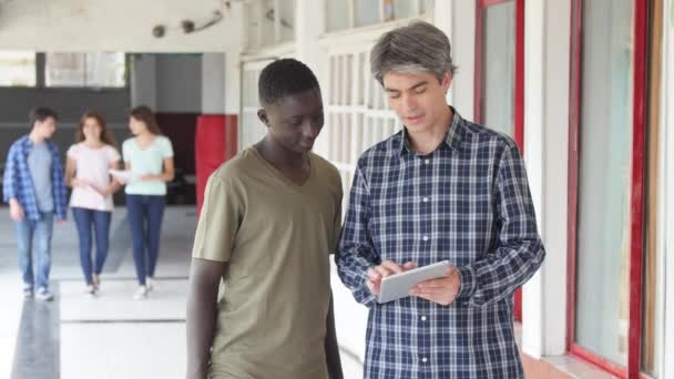 Insegnante a scuola nel corridoio che parla con i suoi studenti. Rallentatore — Video Stock