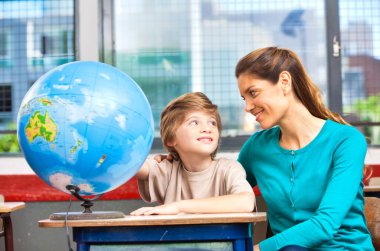 İlkokul sahnesi. Sınıfta öğrencileri olan bir öğretmen..