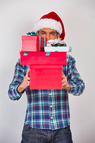 自宅でクリスマスシーン 40代の男は帽子をかぶってギフトボックスを持っている — ストック写真