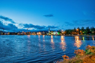 Geceleri Tjornin Gölü boyunca güzel evler, Reykjavik, İzlanda.