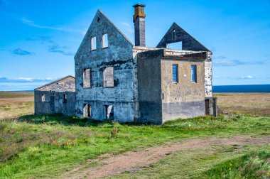 Okyanus kıyısındaki kırsal alanda terk edilmiş bir inşaat. Yalnızlık kavramı.