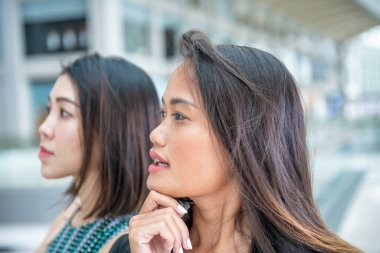 İki güzel Asyalı kadın dışarıda konuşuyor..