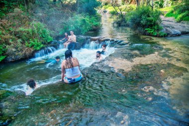 WAIOTAPU, NEW ZEALAND - 1 Eylül 2018: Turistler ve yerliler Kerosene Deresi 'nde doğal termal banyonun keyfini çıkarıyorlar.