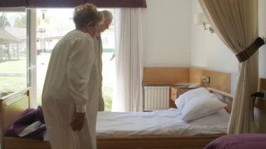 Kafkasyalı yaşlı çiftin yavaş yavaş yatağa girmesi. Mutluluk, rehabilitasyon ve emeklilik kavramı