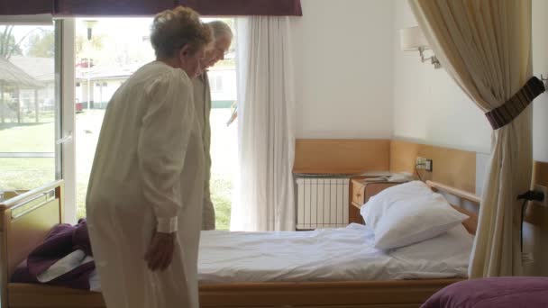 Zeitlupe eines älteren Rentnerehepaares, das ins Bett geht. Glück, Reha und Rentenkonzept — Stockvideo
