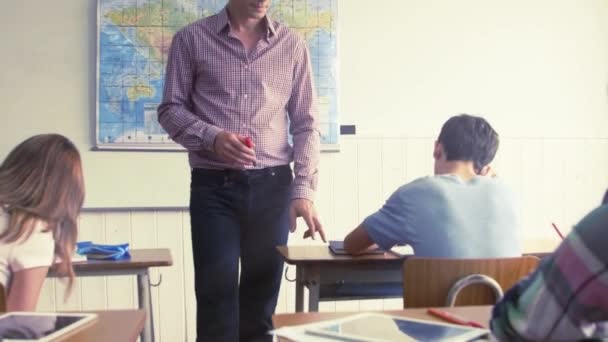 Professor verificando alunos adolescentes trabalha em sala de aula, escola multi étnica Vídeo De Bancos De Imagens