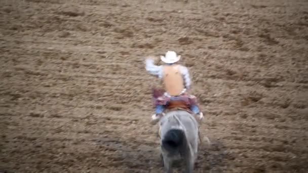 Langzame beweging van cowboy rijden ar rodeo park — Stockvideo