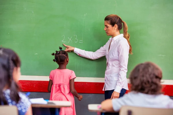 黒板で学校の授業を説明する女教師 学校のコンセプトに戻る — ストック写真