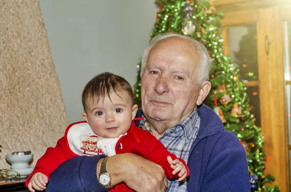 Oudere Man Omarmt Zijn Jonge Kleindochter Thuis Voor Kerstmis — Stockfoto
