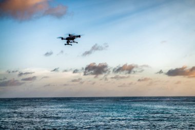 Drone silueti tropik bir adanın üzerinde uçuyor. Tatil, seyahat ve keşif kavramı.