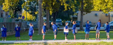 PISA, İtalya - 14 Eylül 2020: İlkokul arkadaşları okulun ilk gününe olan mesafelerini korudular.