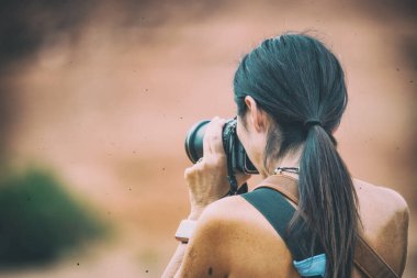 Kadın fotoğrafçı kırmızı dağların, arka görünümün fotoğraflarını çekiyor..
