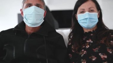 50 'li yıllarda anne babasıyla koronavirüs acil durumlarında yüz maskesi takan bir çiftin webcam görüntüsü. Aile zamanı, eğlenceli aktivite konsepti