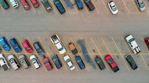 Aerial view of cars at large outdoor parking lots, USA. Outlet mall parking congestion and crowded parking lot, other cars try getting in and out, finding parking space.