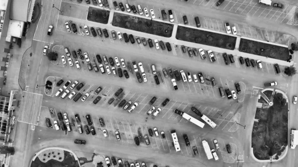 Aerial view of cars at large outdoor parking lots, USA. Outlet mall parking congestion and crowded parking lot, other cars try getting in and out, finding parking space.