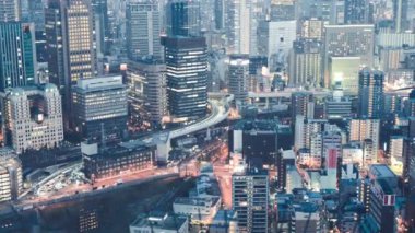 Osaka şehrinin panoramik manzarası geceleri çatıdan yükseliyor, Japonya. Yavaş çekim