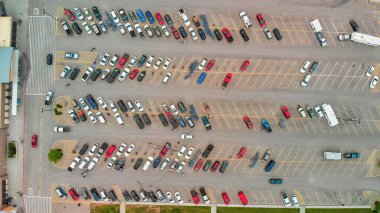 Büyük açık hava otoparklarındaki arabaların havadan görüntüsü, ABD. Outlet alışveriş merkezinin park yeri sıkışıklığı ve kalabalık otopark; diğer arabalar girip çıkmayı deniyorlar; park yeri buluyorlar. Panorama; İHA bakış açısı