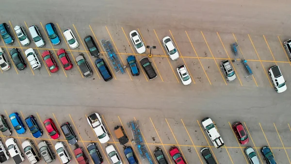 Aerial view of cars at large outdoor parking lots; USA. Outlet mall parking congestion and crowded parking lot; other cars try getting in and out; finding parking space. Panorama; downward drone viewpoint