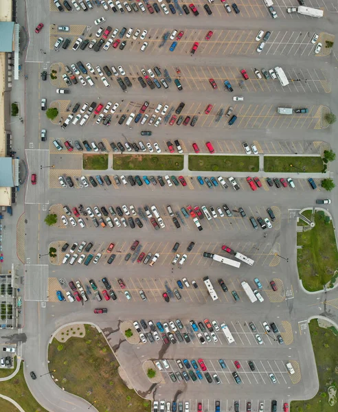 Aerial view of cars at large outdoor parking lots; USA. Outlet mall parking congestion and crowded parking lot; other cars try getting in and out; finding parking space. Panorama; downward drone viewpoint