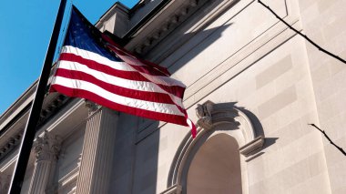 Amerikan Bayrağı büyük bir şehir binasının önünde dalgalanıyor. Yavaş çekim