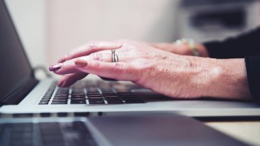 Kadın eli dokunmatik ve klavye kullanarak bir defter üzerinde çalışıyor, kapat. Yavaş çekim