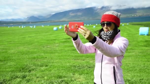 Mujer tomando selfies en un hermoso entorno rural. Movimiento lento — Vídeo de stock