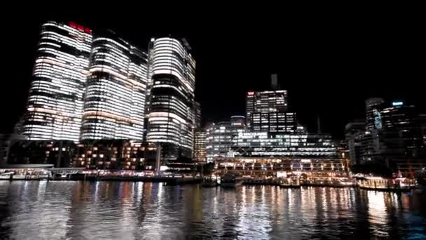 Vista nocturna de los rascacielos Barangaroo desde un barco en movimiento, Sydney — Vídeo de stock