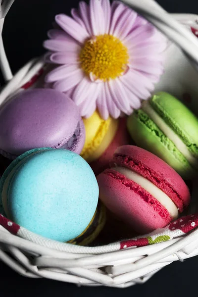 Sortidas Macaroons Franceses Cesta Branca Com Flores Fundo Preto — Fotografia de Stock