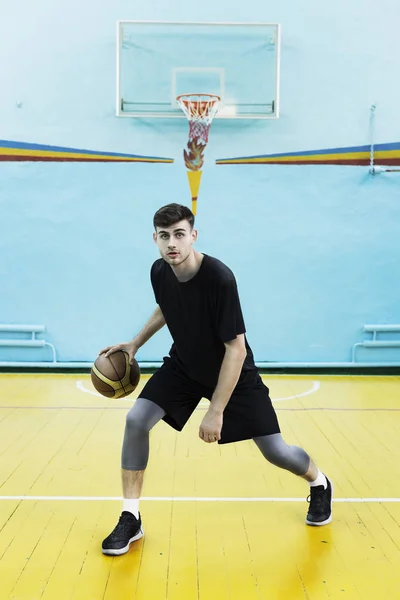 Young man, basketball player in action in a basketball court