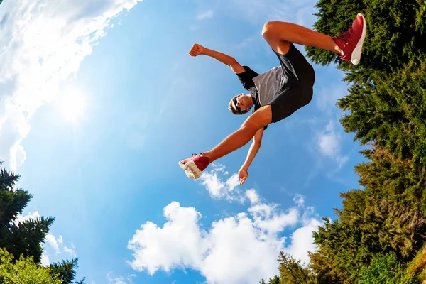 男の子は 山の牧草地にジャンプします 下からを表示します 夏のシーズン フィッシュアイ レンズ — ストック写真