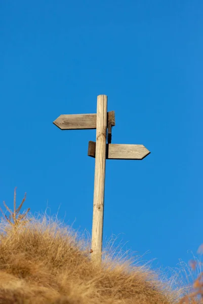 Wooden signpost and blue sky. Copy space on the top.