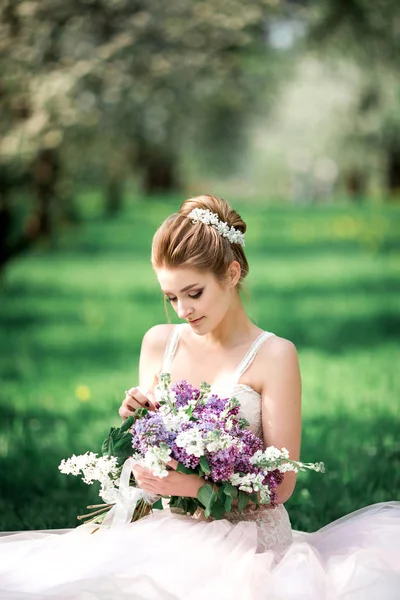 花リンゴの木の枝と美しい少女の手 咲く庭で若い美しいブロンドの女性 — ストック写真