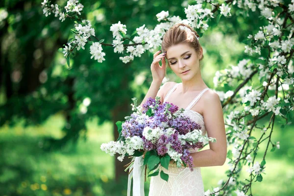 Portrait of beauty bride in white dress. The bride is holding a wedding bouquet of lilacs