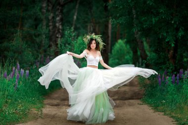 Gelini güzel beyaz elbise ve orman çiçek çelenk