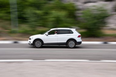 Bulanık arka plan ile yolda beyaz arabanın yan görünümü