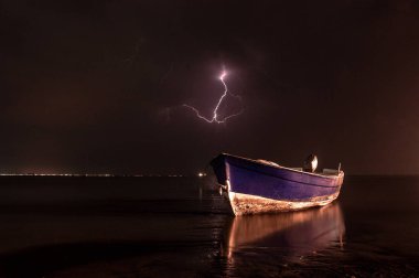 Gece gökyüzü arka plan, Durres, Arnavutluk üzerinde fırtına yıldırımlar ile su üzerinde Tekne 