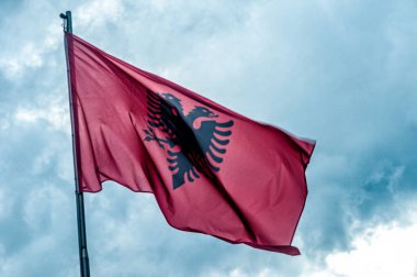 Arnavutluk bayrağı mavi gökyüzü arka plan karşı rüzgar da bayrak sallayarak 