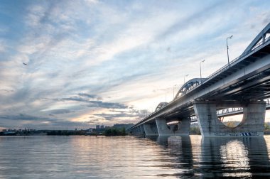 Günbatımında Dnieper Nehri 'nin karşısındaki Darnitsky köprüsünün panoramik görüntüsü, Kiev, Ukrayna  