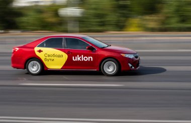 Ukrayna, Kyiv - 24 Eylül 2020: Uklon taksi kırmızı araba caddede ilerliyor