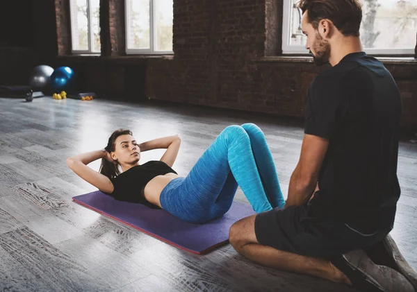 Personal trainer helps a girl with the gym exercises — Stock Photo, Image