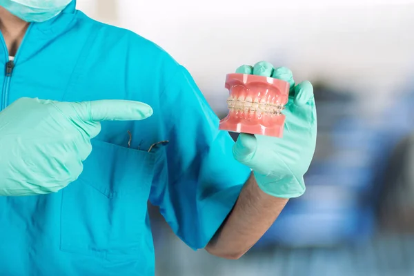 Οδοντίατρος δείχνει πώς να εφαρμόζουν ένα στήριγμα — Φωτογραφία Αρχείου