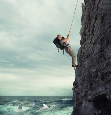 Explorer bir dağ ile denizde köpekbalıkları ile düşmek için risk tırmanıyor