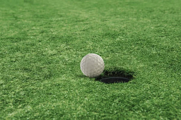 Golfball in der Nähe des Lochs in einem Rasenfeld — Stockfoto