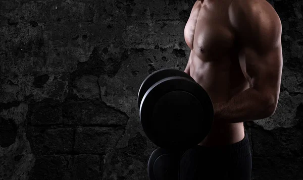 Hombre atlético entrenando bíceps en el gimnasio — Foto de Stock