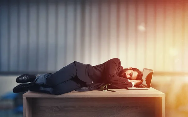 Empresário dormindo sobre uma mesa devido ao excesso de trabalho — Fotografia de Stock
