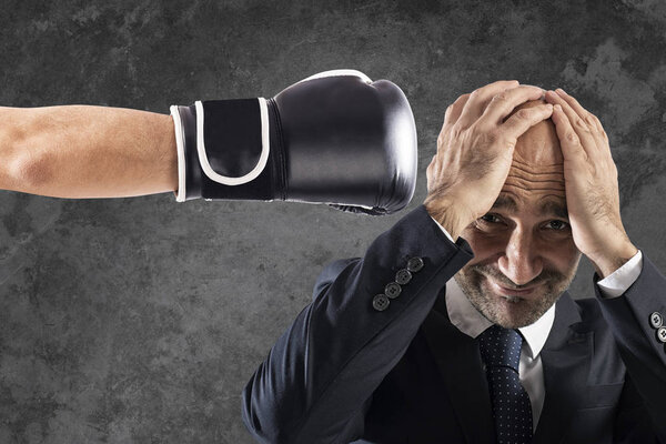 Businessman receives fists from competitors. concept of difficult career