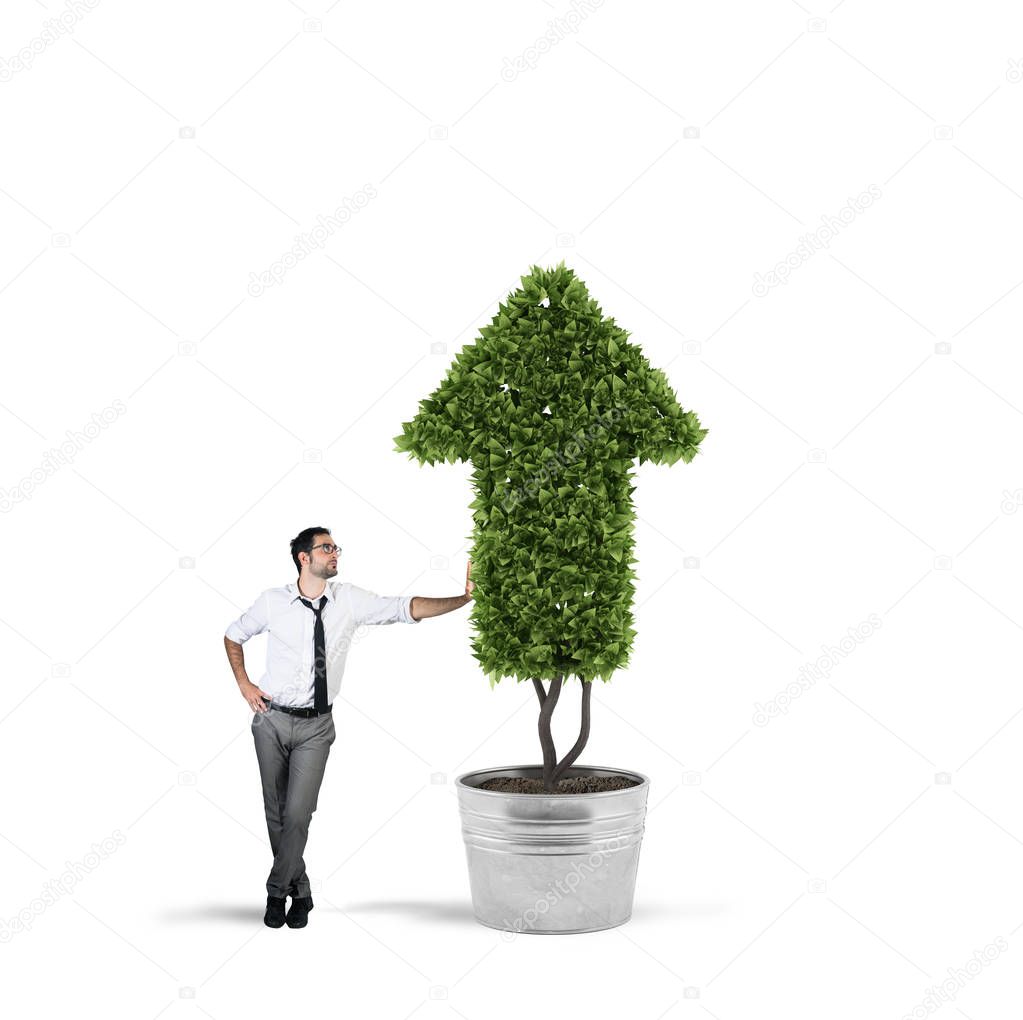 Businessman that cultivates a plant with a shape of arrow. Concept of growing of company economy .